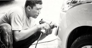 person waxing a car