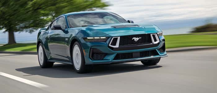 Blue 2025 Ford Mustang driving on the road