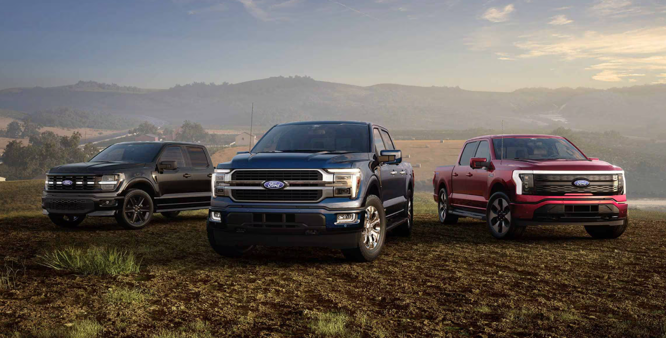 Three Ford F-150s parked in grass