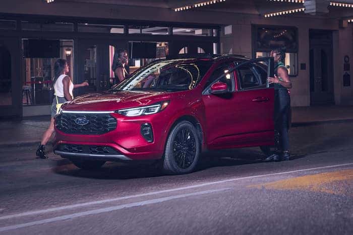 Passengers getting into a red ford escape