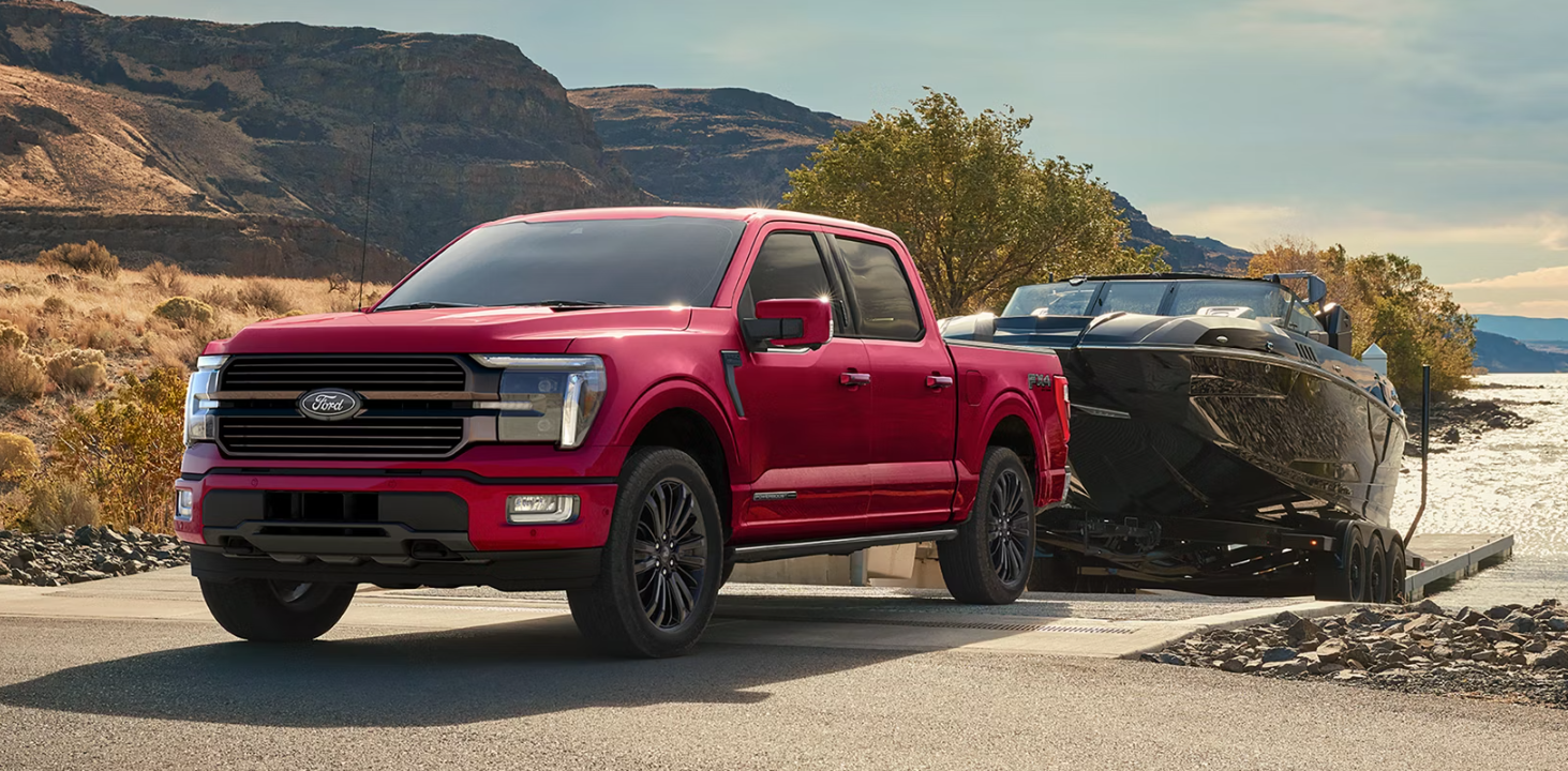Red 2026 Ford F-150 Hybrid towing a boat