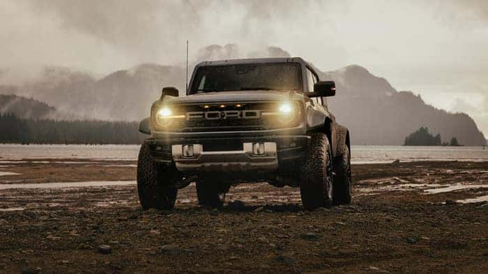 Brown Ford Bronco parked in the dirt facing the front