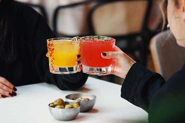 A couple of people sitting at a table with drinks