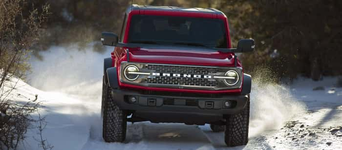 Red Ford Bronco driving in the snow