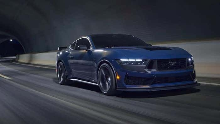 Blue Ford Mustang driving on the road
