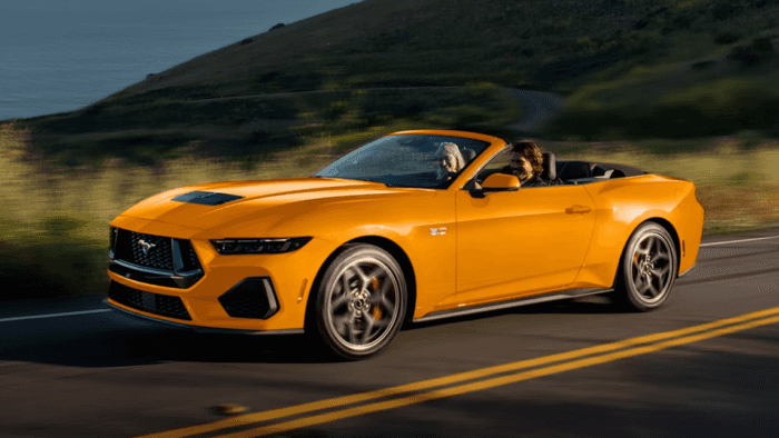 Orange 2026 Ford Mustang Convertible driving on the road