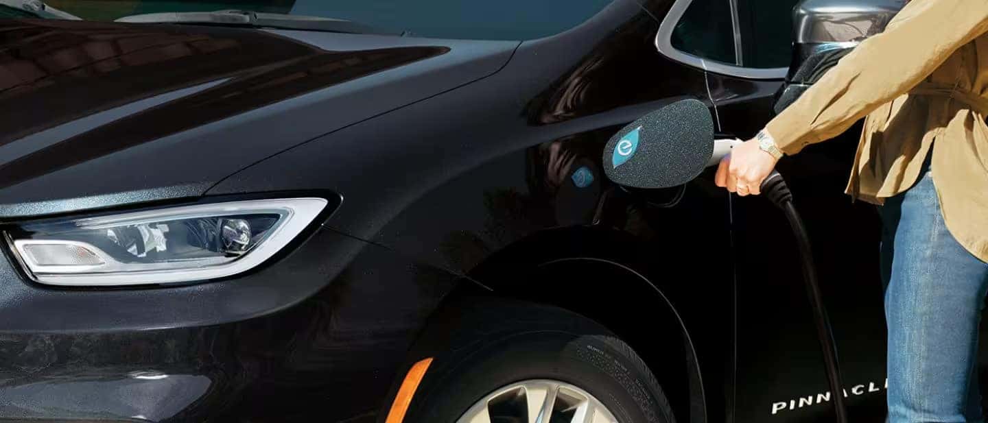 woman charging a 2024 Chrysler Pacifica Hybrid