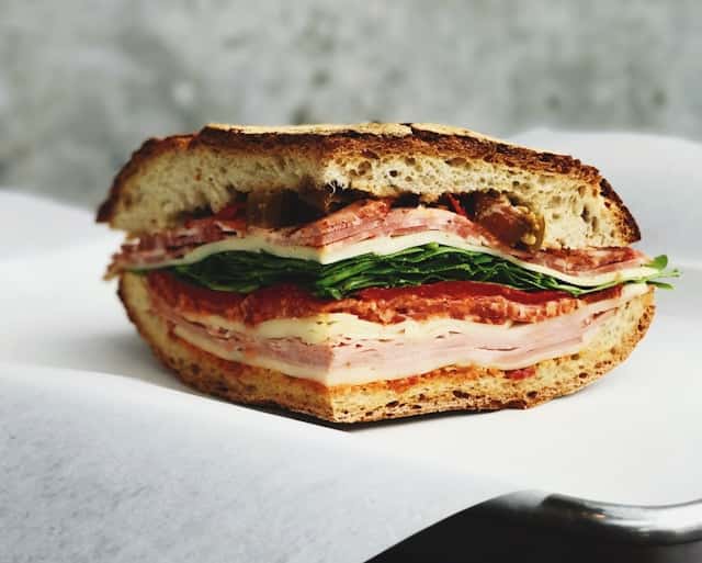 Ham sandwich on white surface