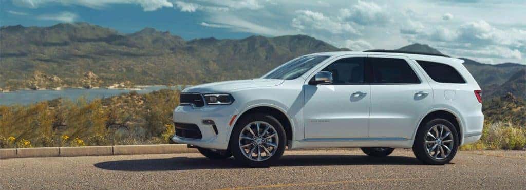 Dodge Durango driving down a road with mountains in the background
