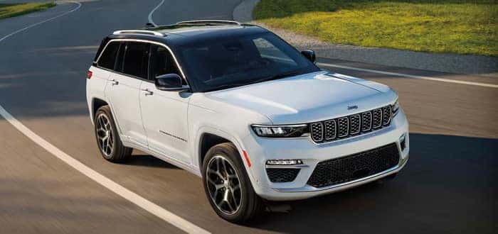 White Jeep Grand Cherokee driving on the road