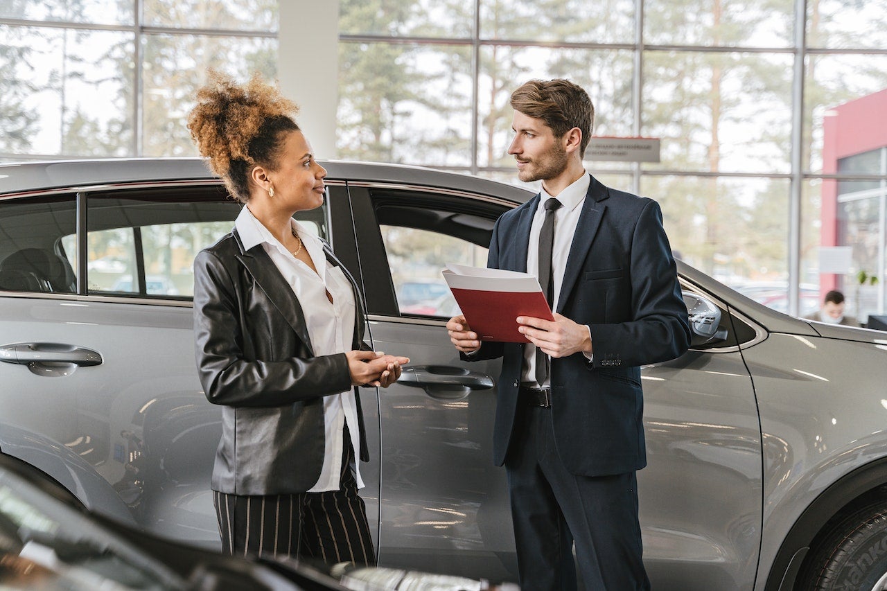 woman buying a car from dealer