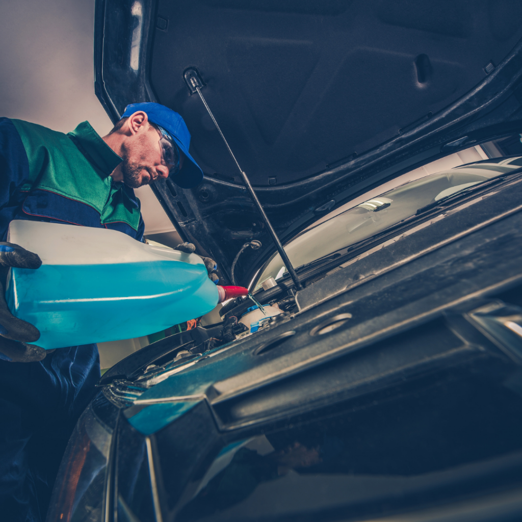 Mechanic performing fluid replacement service on a car