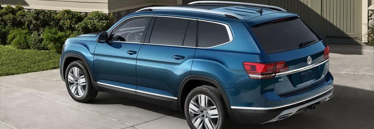 blue 2020 Volkswagen Atlas Cross Sport parked in a driveway in front of a home