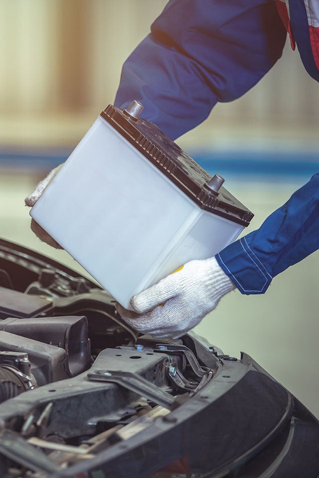 Everything You Need to Know about Your Car Battery at Bennett Toyota of Lebanon | Close Up of Mechanic Pulling Car Battery Out of Engine