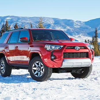 How to prepare your Toyota for the winter season in Lebanon, PA at Bennett Toyota of Lebanon | 4Runner parked on snowy mountain side with pine trees in background