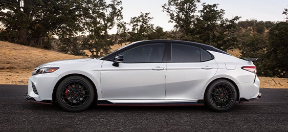 Model Features of the 2022 Toyota Camry at Bennett Toyota of Lebanon | Side profile of Camry on back road