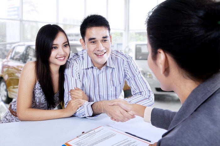 Car buyer shaking hands with car dealer