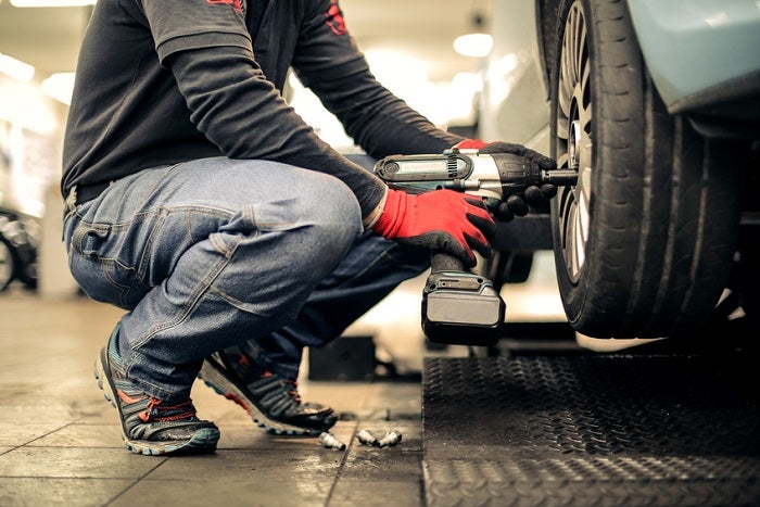 Mechanic replaces a tire on a car
