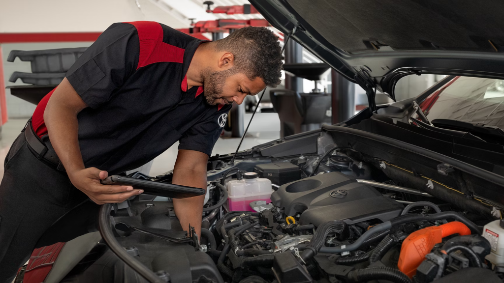 Summer Road Trip Prep - Toyota Technician checking under the hood of a Toyota