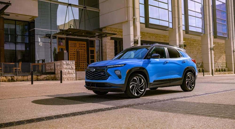 A blue 2024 Chevy Trailblazer RS parked outside a downtown restaurant.