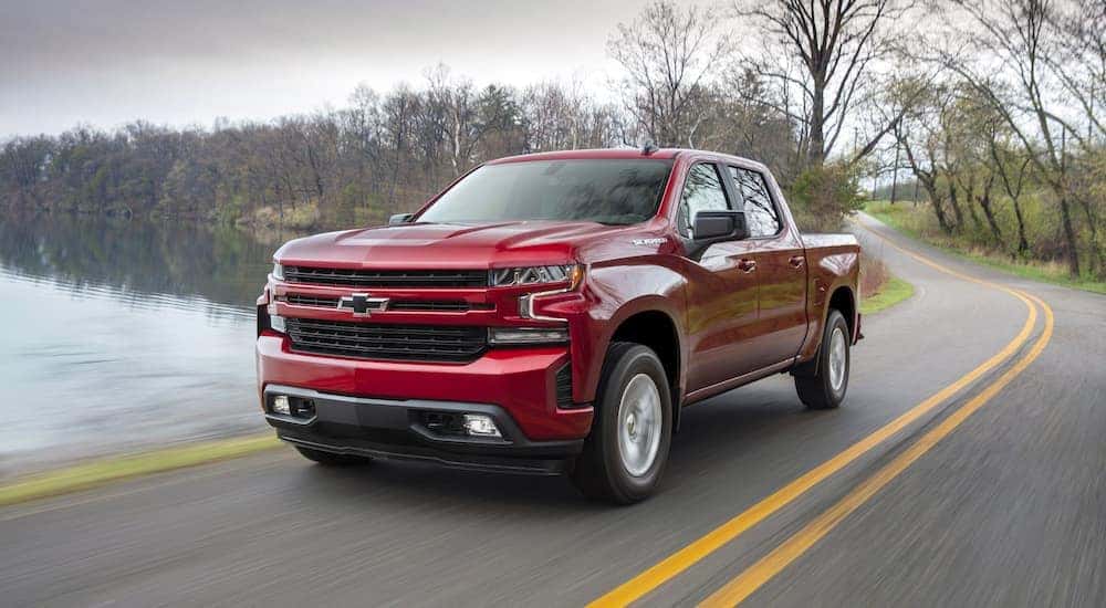 A red 2019 Chevy Silverado 1500 RST driving by a lake.