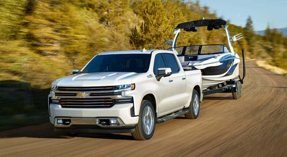 A white 2020 Chevy Silverado 1500 is towing a boat.