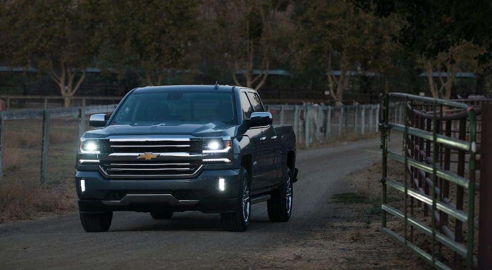 A black 2018 used Chevy Silverado is parked next to a fence.