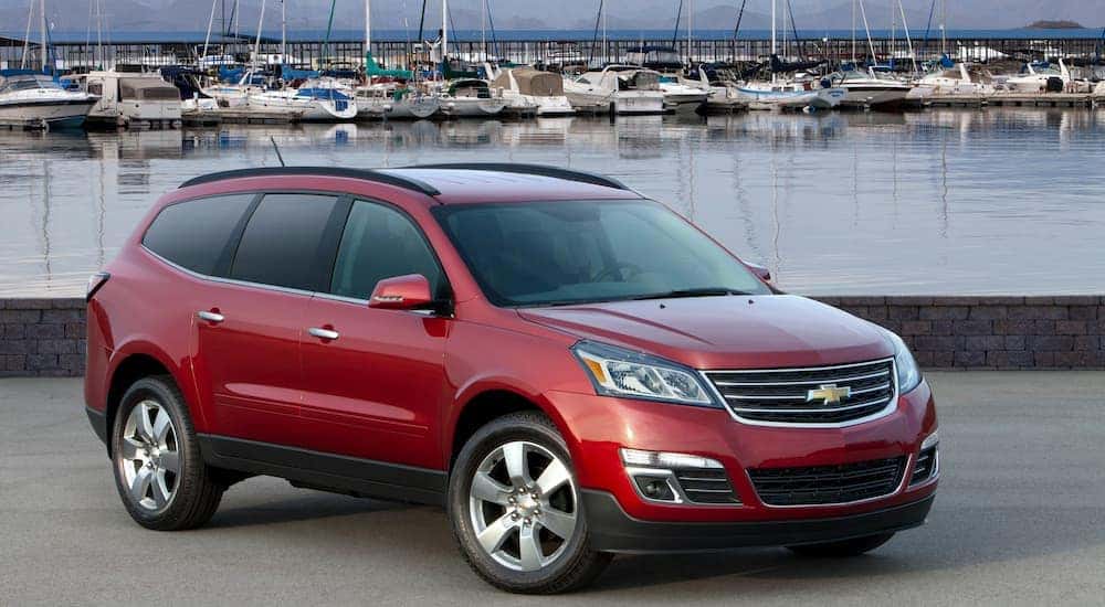 A red 2014 used Chevy Traverse LTZ is parked at a marina.