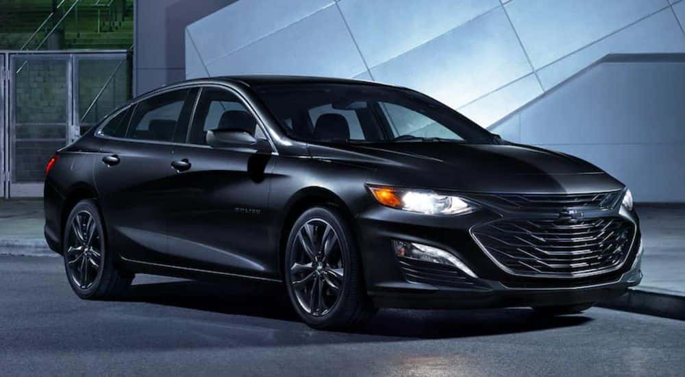 A black 2021 Chevy Malibu is parked in a gallery.