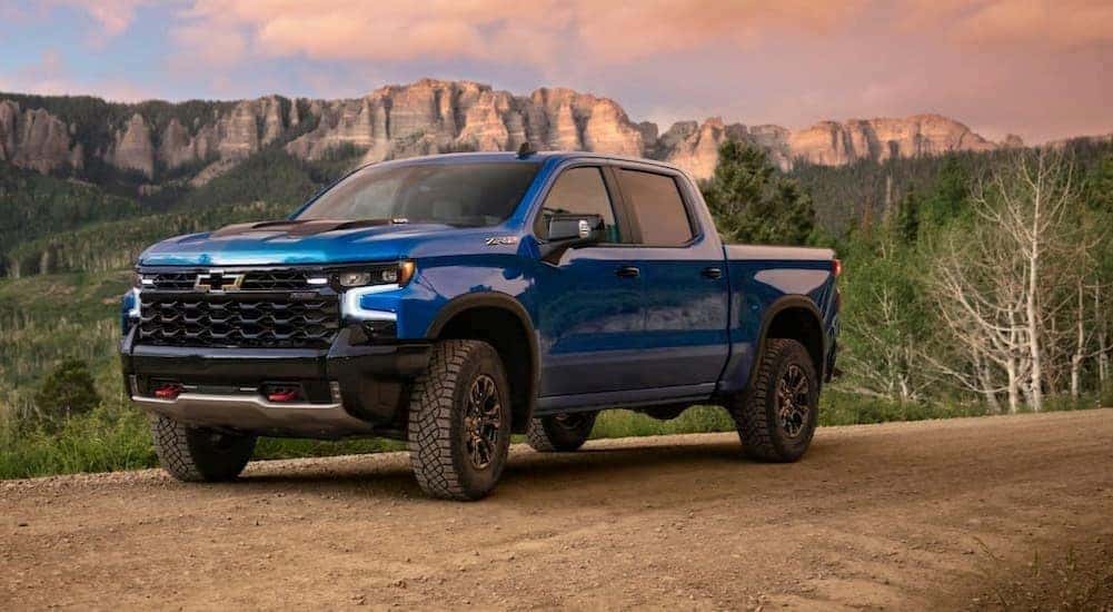A popular Chevy Silverado 1500 for sale, a blue 2024 Chevy Silverado 1500 ZR2, is shown parked off-road.