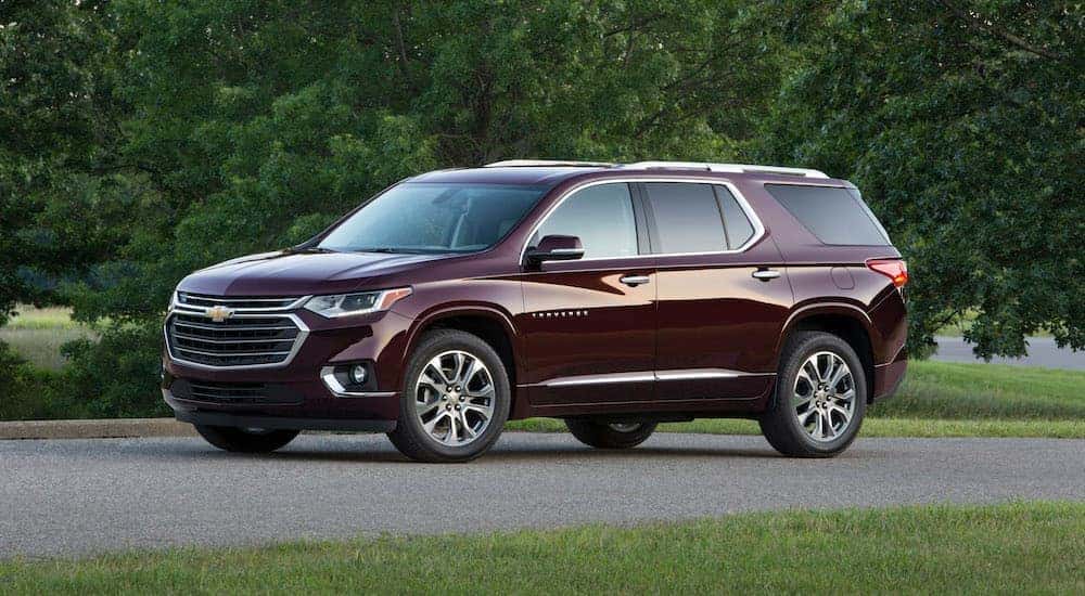 A purple 2018 used Chevy Traverse is parked with trees in the background.