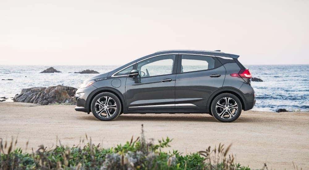 A black 2017 Chevy Bolt EV is shown from the side on a beach.