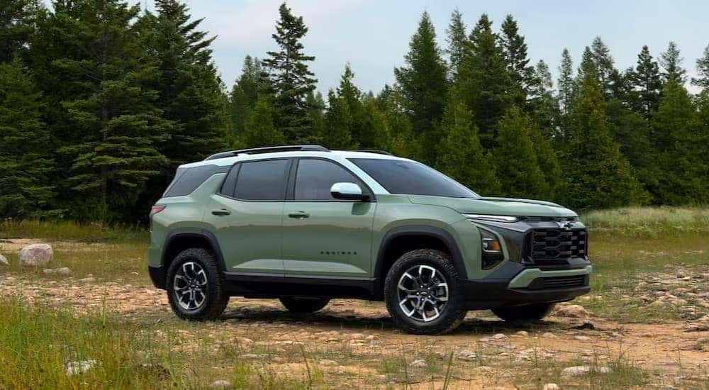 A green 2025 Chevy Equinox ACTIV is shown parked off-road after visiting a Chevy dealer.