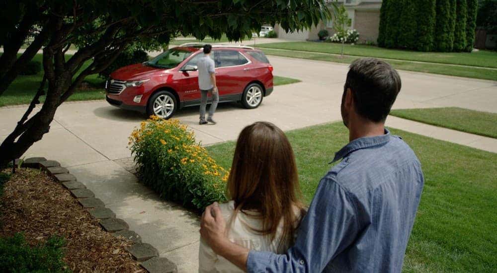 Parents are watching their son walk to a red 2018 Chevy Equinox in the driveway of a Lexington, KY, house.