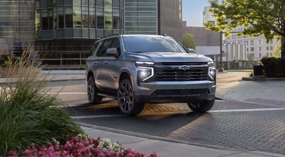 A silver 2025 Chevy Tahoe RST driving to a Chevy dealer near Louisville.