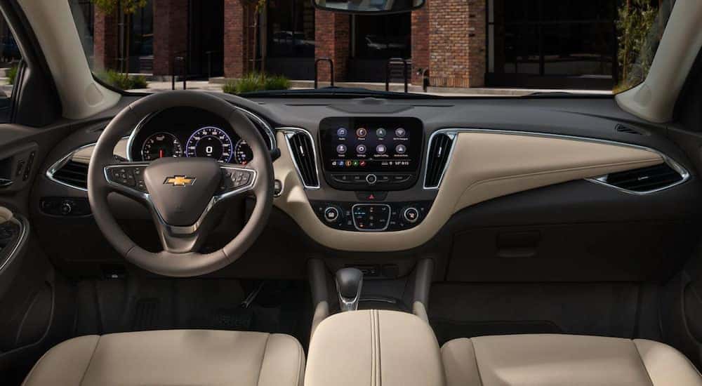 The interior of a 2021 Chevy Malibu shows the steering wheel and infotainment screen. 