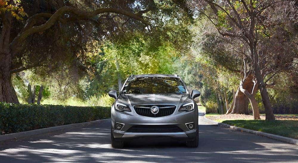 A grey 2021 Buick Envision is parked on a shady street.
