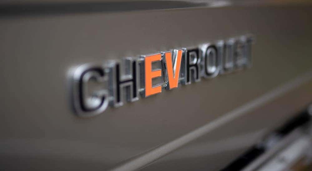 An emblem that says Chevrolet has the EV in orange while the rest is black for a Chevy EV SEMA K5 Blazer build.