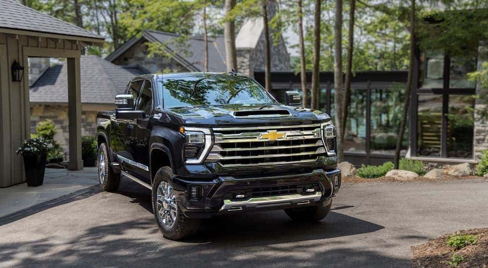 A black 2024 Chevy Silverado 2500 HD is shown from the front at an angle after leaving a dealer that has a Chevy Silverado 2500 for sale.