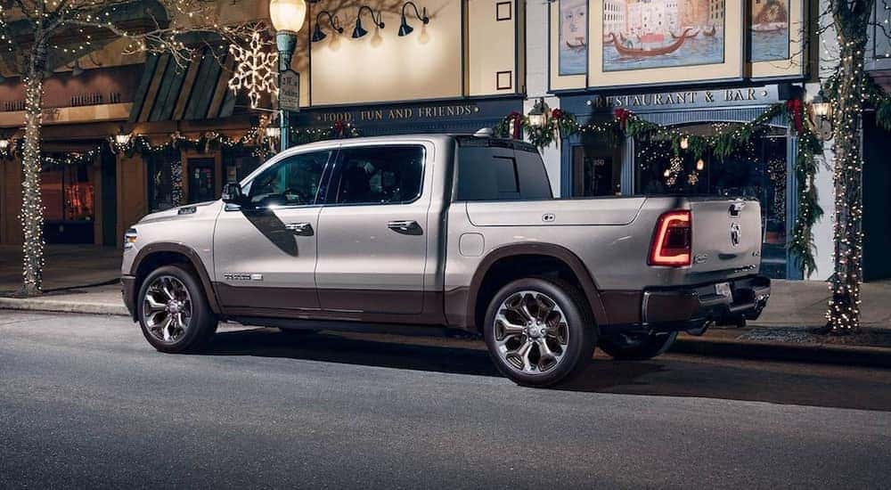 A silver 2020 Ram 1500 diesel is parked in front of a shop covered in Christmas decorations.
