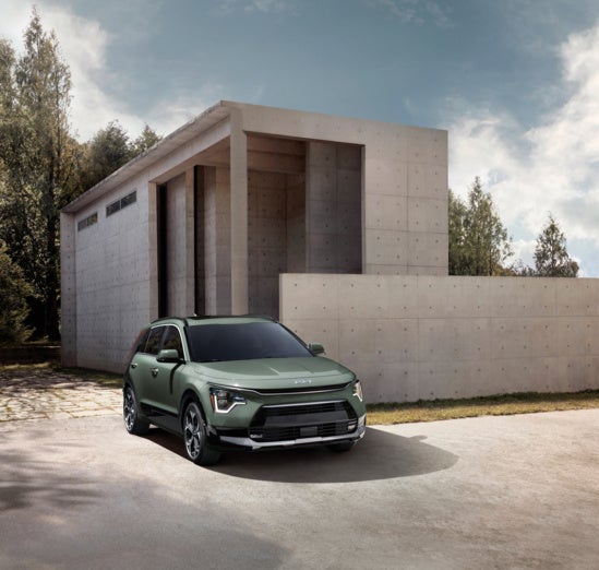 2024 Kia Niro EV parked in front of a modern concrete building.