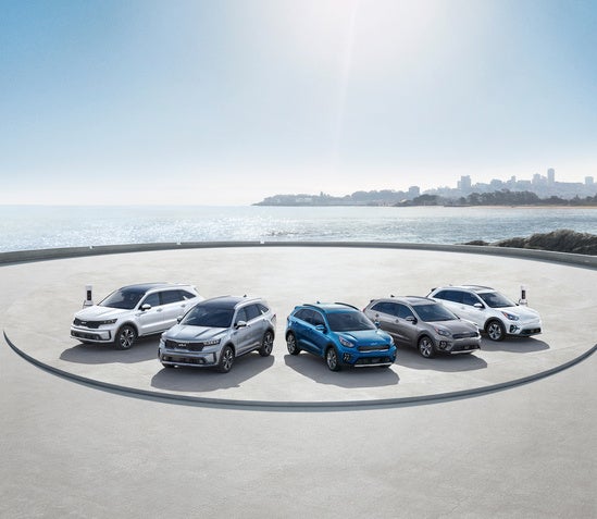 Kia line-up of cars parked on a circular platform by the seaside.