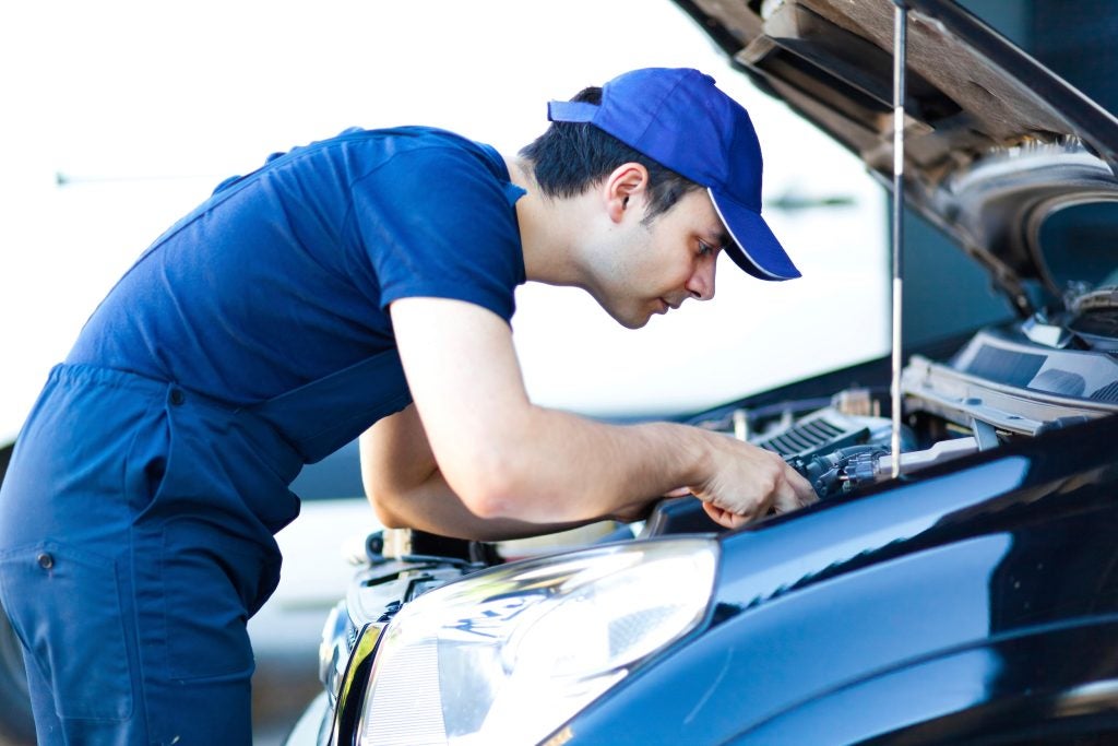 A service employee in a blue uniform recording information.