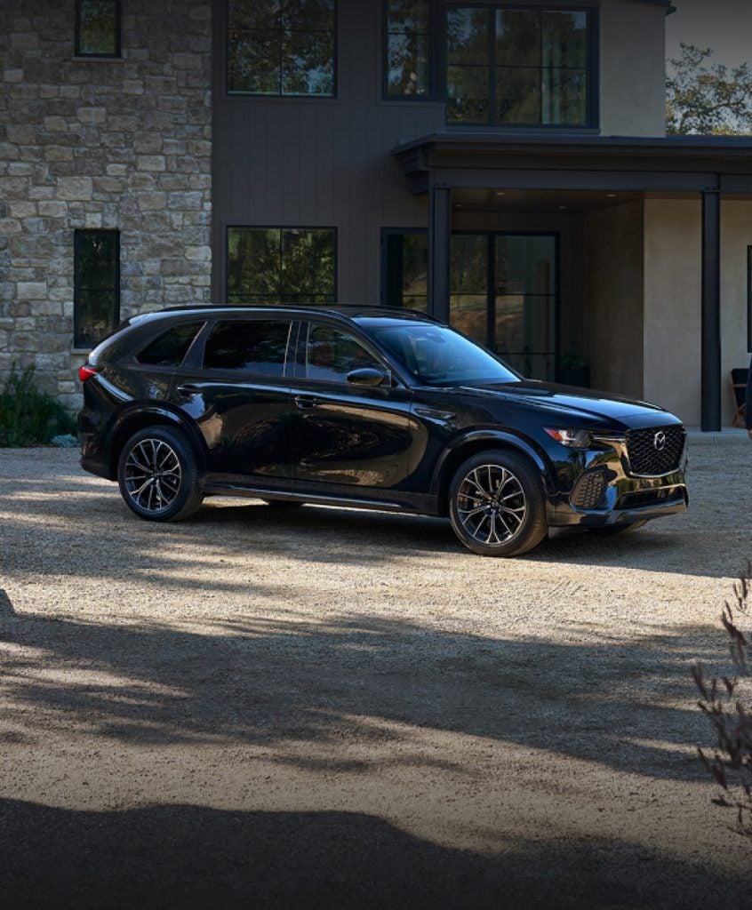 Black 2025 Mazda CX-70 PHEV, a midsize crossover SUV, shown in a front three-quarters view.