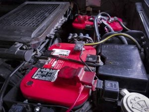 Optima battery installed in an engine of a vehicle with all of the cables and wires attached to it.