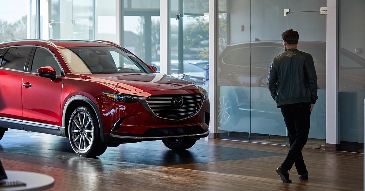 Man walking through a Mazda dealership