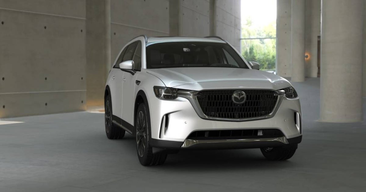 Mazda CX-90 SUV in white, front three-quarter view indoors