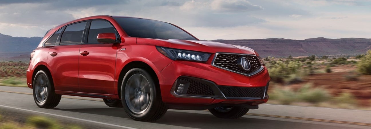 A red 2019 Acura MDX driving down the road