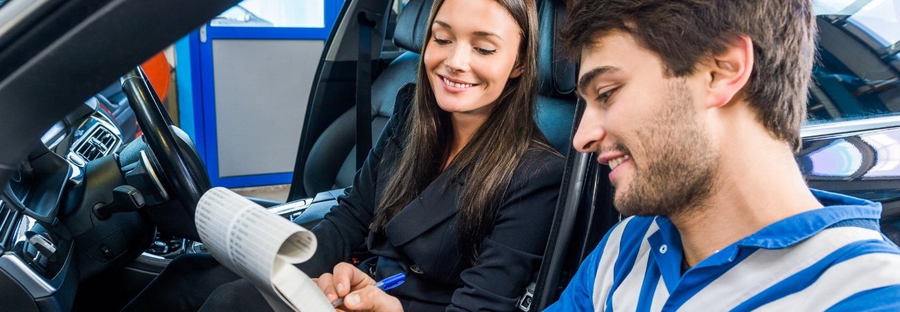 Two people going over a car maintenance checklist