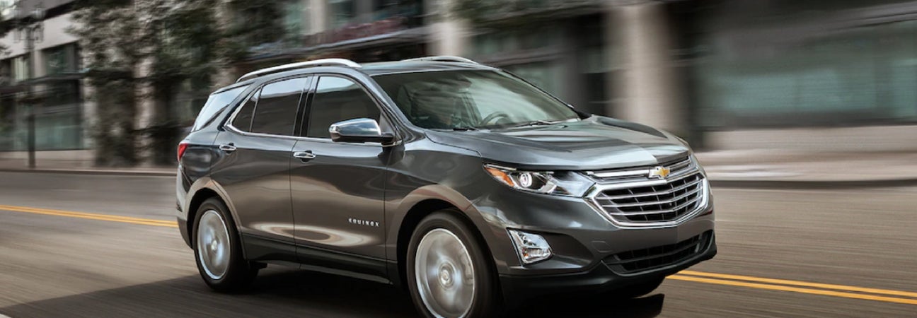 Metallic Chevy Equinox driving down city streets